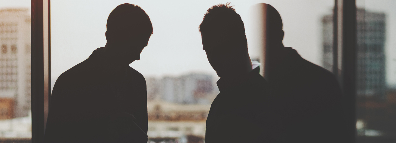 silhouette of two men in an office